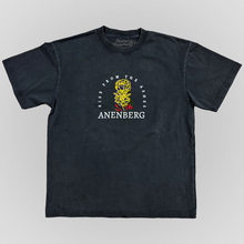Front view of the Anenberg From the Ashes Tee featuring a vintage-washed charcoal black oversized T-shirt with a detailed embroidered golden yellow rose rising from red flames. White Rise From the Ashes lettering arches around the floral design, with the ANENBERG wordmark embroidered below. This heavyweight 7.5 oz boxy-fit T-shirt combines premium embroidery, a relaxed silhouette, and vintage-inspired Southern California streetwear styling.

