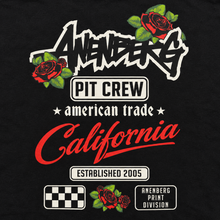 Close-up of the Anenberg Pit Crew Black Tee back graphic featuring bold Anenberg lettering, red roses, Pit Crew and American Trade logos, red California script, Established 2005 branding, racing checkerboard, and Anenberg Print Division artwork. California-inspired streetwear design.